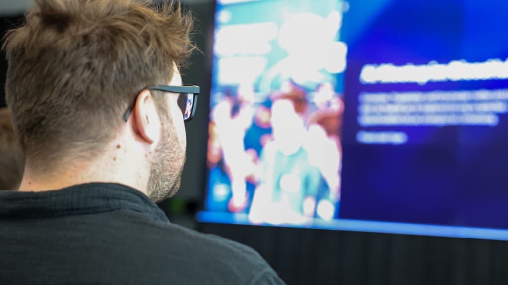 Zuschauerperspektive auf eine blau hinterlegte Präsentationsfolie.