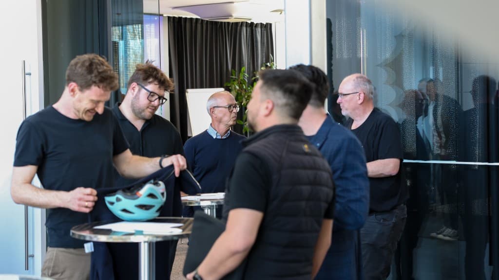 Teilnehmende im Gespräch in heller, moderner Eventlocation.