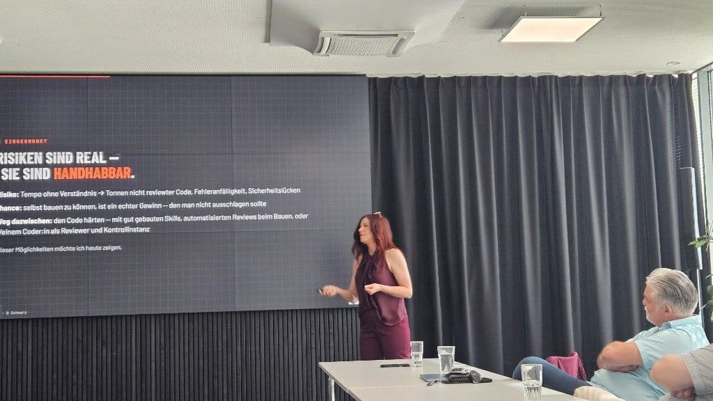 Nina Fleisch vor der Folie „Risiken sind real – sie sind handhabbar“ mit Hinweisen zu Code-Reviews und Skills.