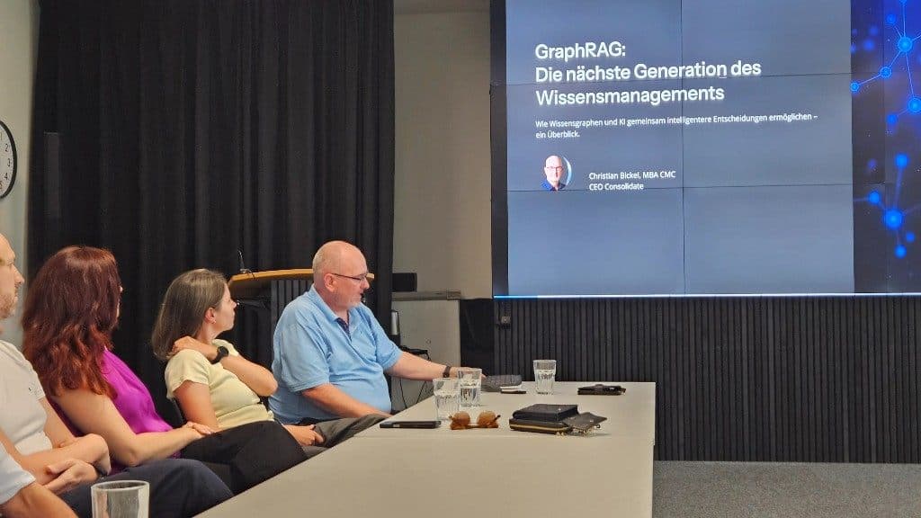Titelfolie „GraphRAG: Die nächste Generation des Wissensmanagements“ mit Christian Bickel am Tisch.