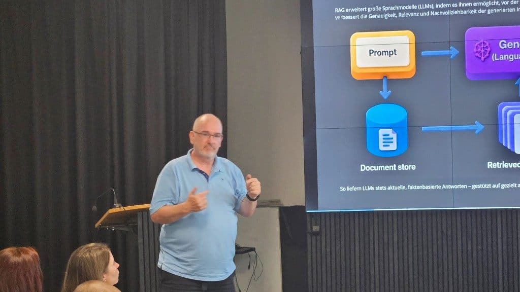 Christian Bickel erläutert das RAG-Schema mit Prompt, Document Store und Generator auf der Leinwand.